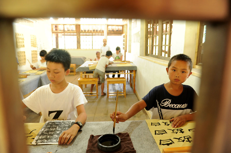 8月17日，孩子們在國學班課堂上練習書法。